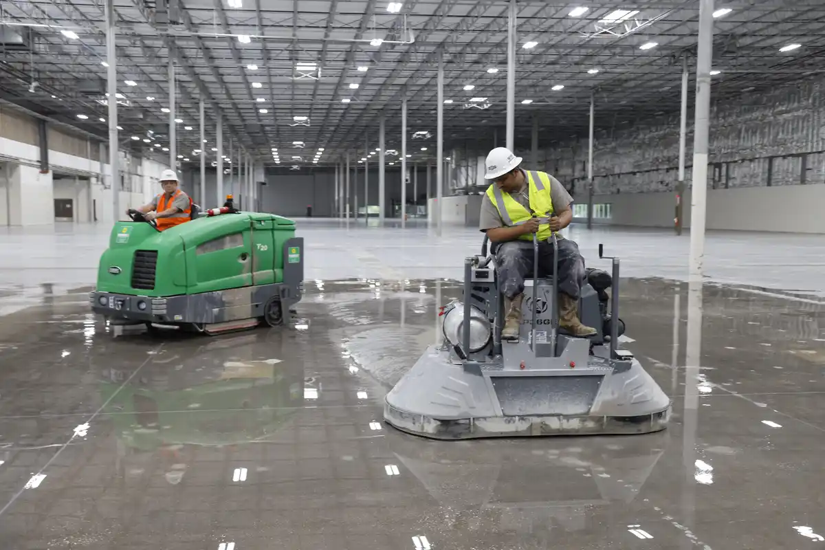 Diamond crew processing the 120,000 SF warehouse polished concrete rehabilitation with power-trowel equipment